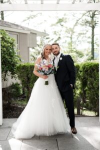 Bride and groom posing together outdoors on their wedding day.