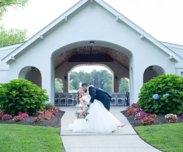 Bride and groom share a kiss under a gazebo after their wedding ceremony.