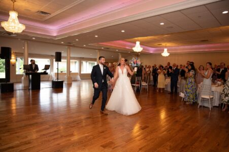 Bride and groom dance joyfully at their wedding reception.
