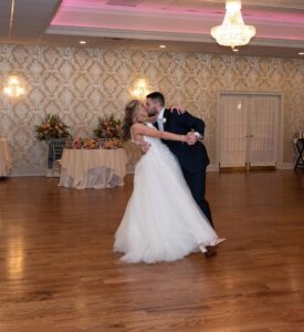 Bride and groom dancing elegantly in a decorated hall.