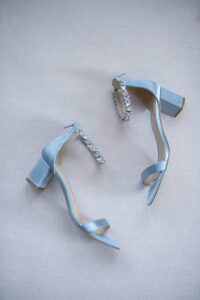 Elegant light blue high-heeled sandals with ankle straps and decorative buckles.