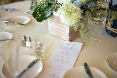 Elegant wedding table setting with menu and floral centerpiece.