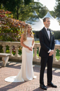 Bride and groom standing together outdoors during wedding ceremony.