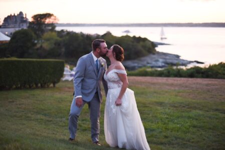 Bride and groom sharing a kiss outdoors at sunset.