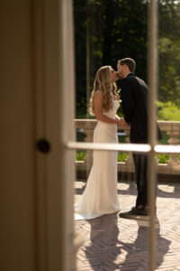 Bride and groom share a kiss outdoors on their wedding day.
