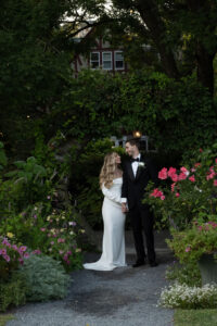 Bride and groom share a romantic moment in a lush garden.